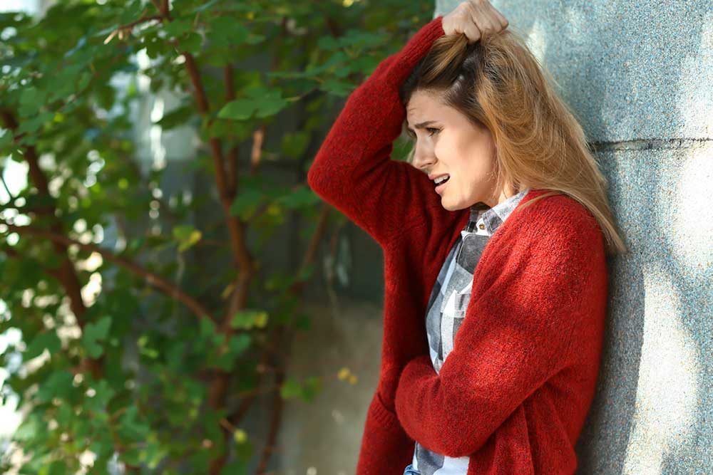 Woman having a panic attack outdoors.