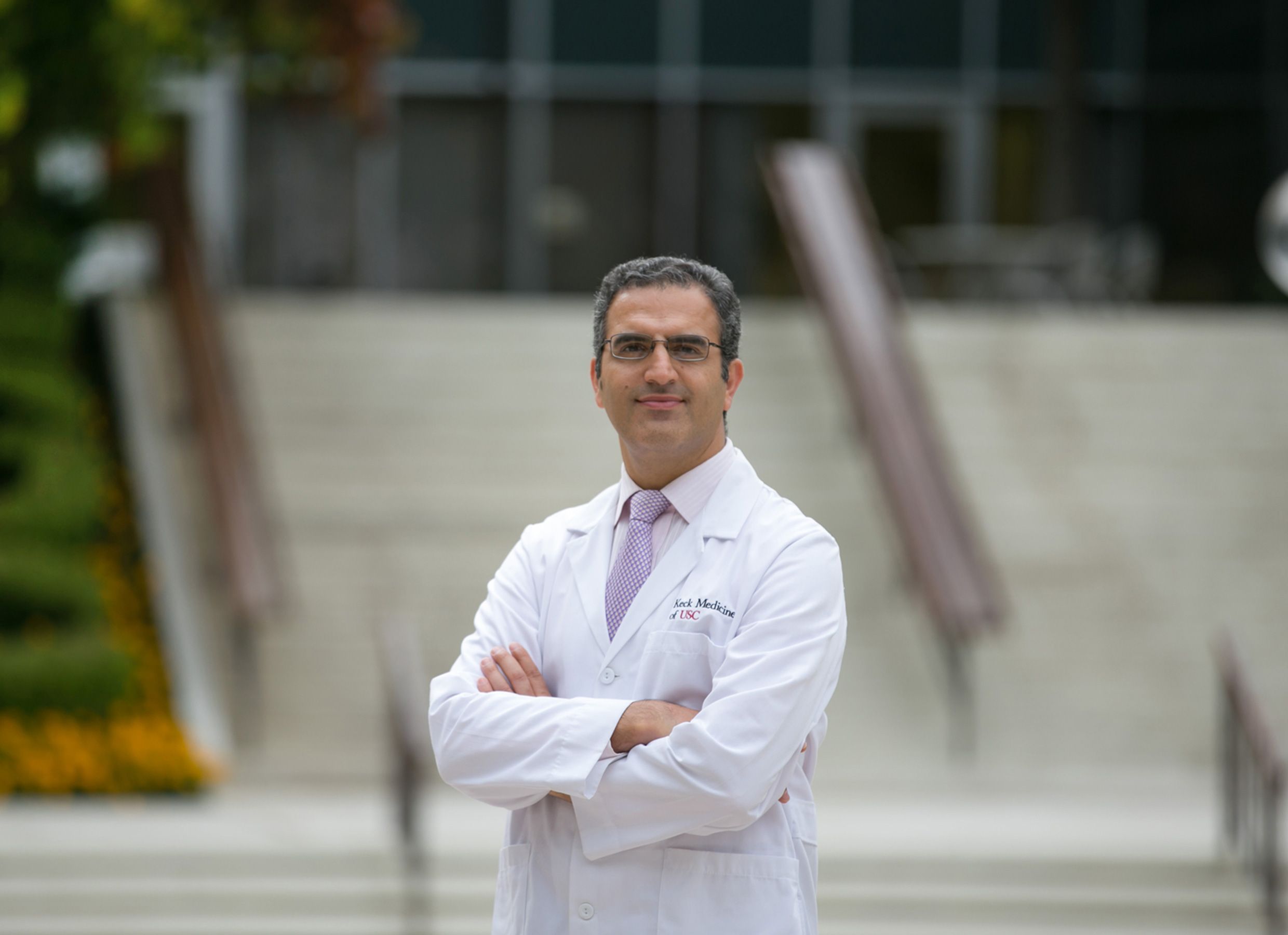 Urologist Dr. Hooman Djaladat stands in front of a building on USC's Health Sciences Campus