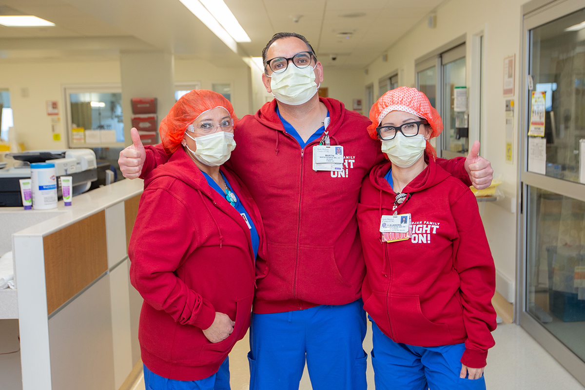 Three Keck Medicine of USC health care employees in a hospital hallway