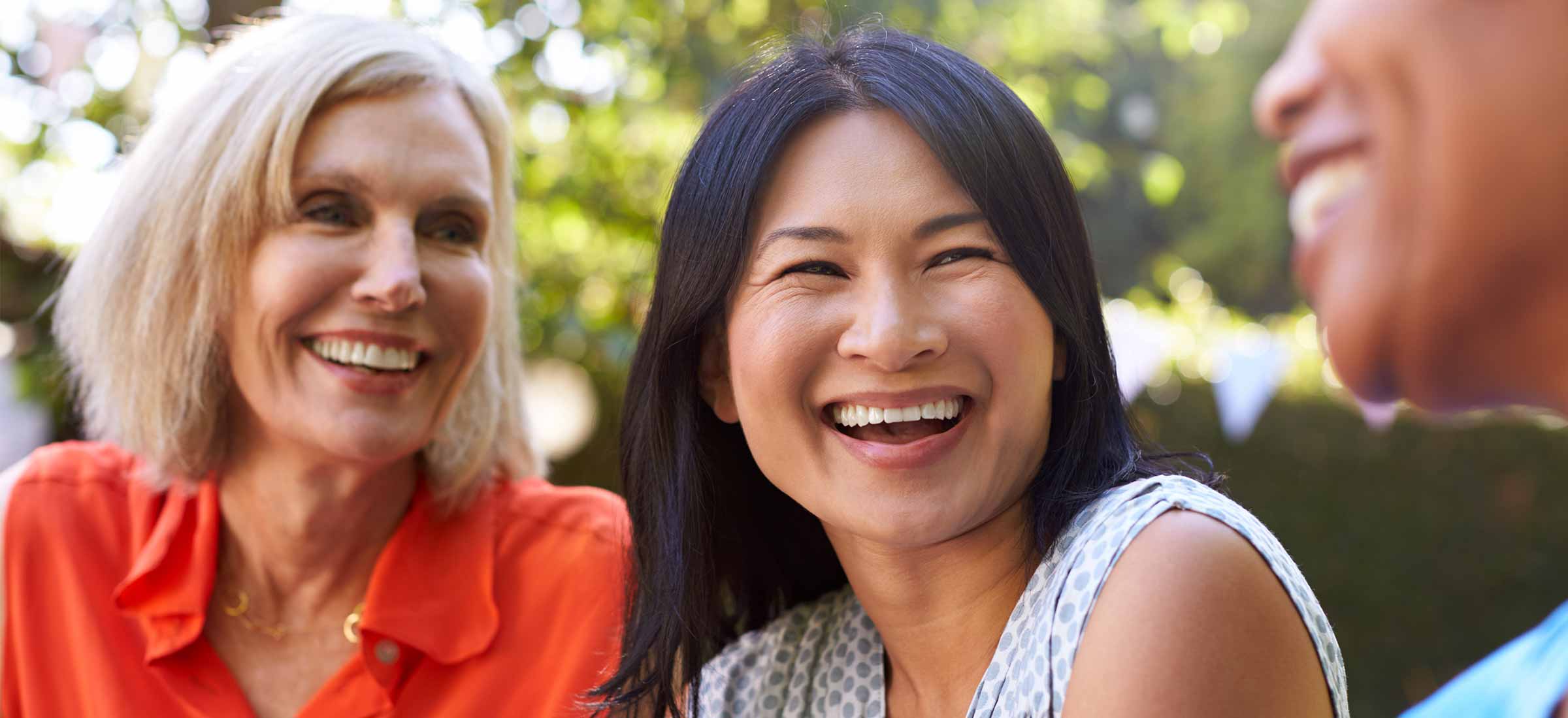 Mature female friends socializing in backyard together.