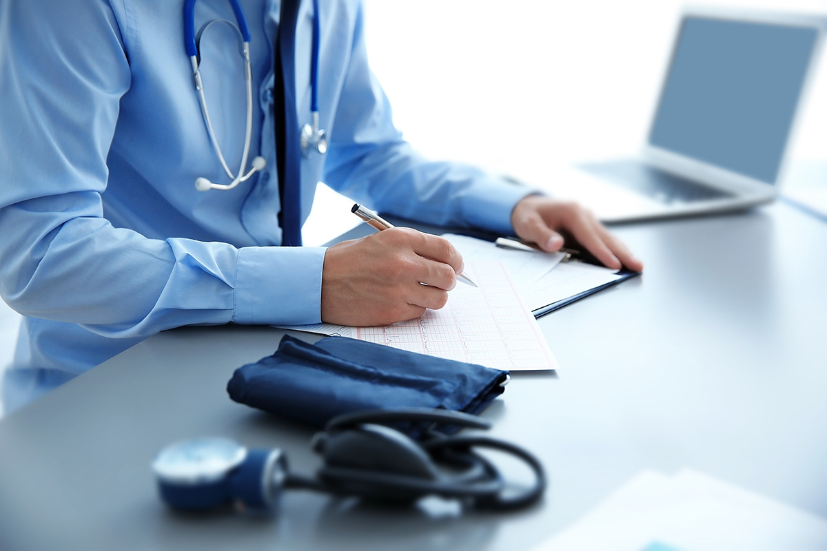 Cardiology doctor filling out paperwork at a desk