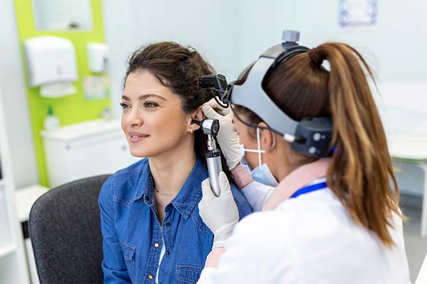 A doctor inspects a patient's ear.