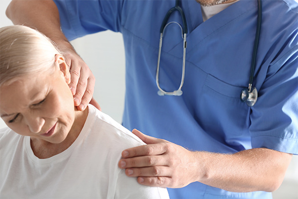 A doctor touches a woman's neck.