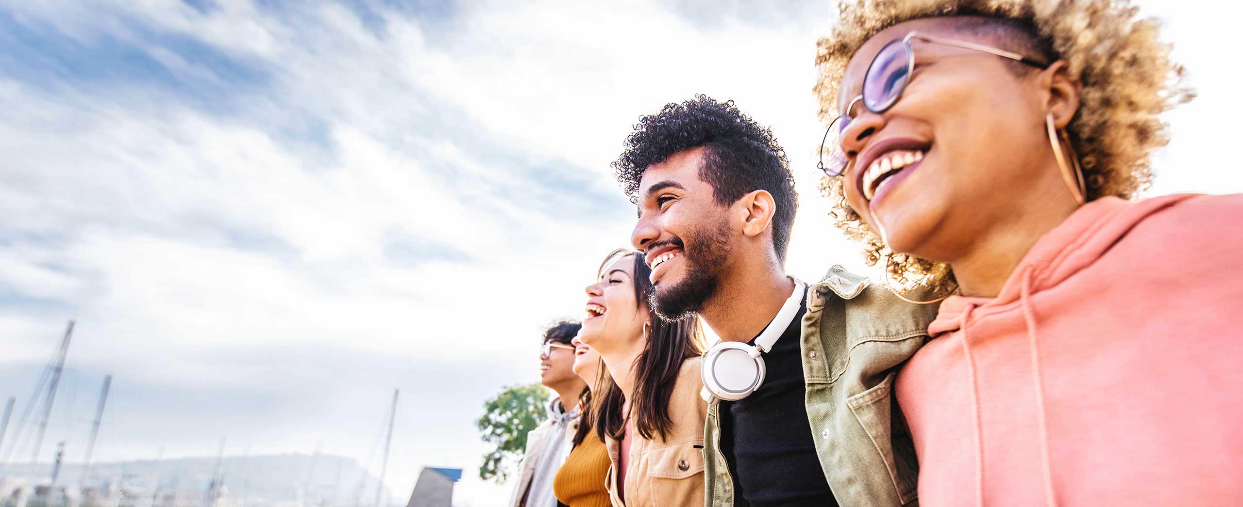 Multiracial group of friends hugging together outside