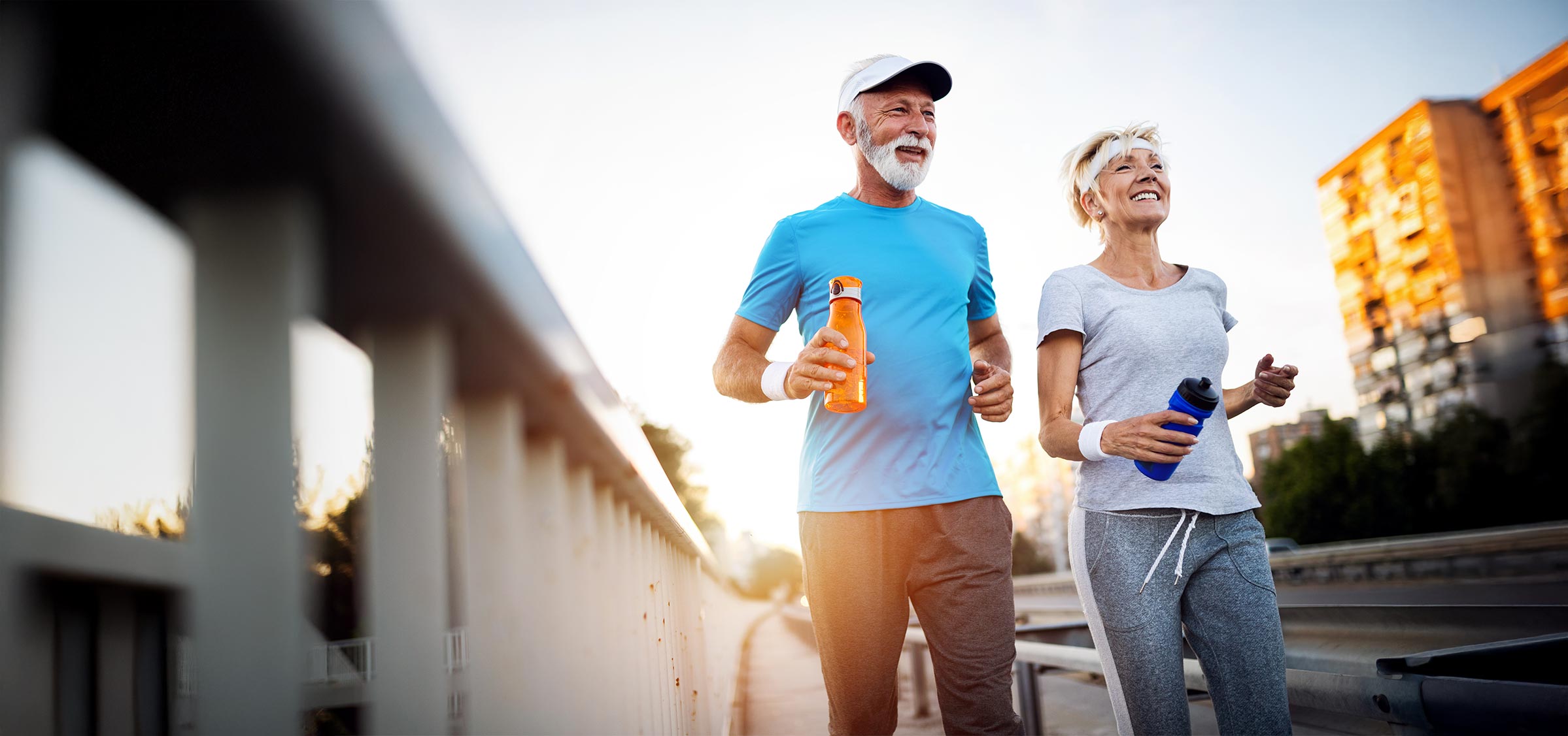 Mature couple jogging and running outdoors in a city.