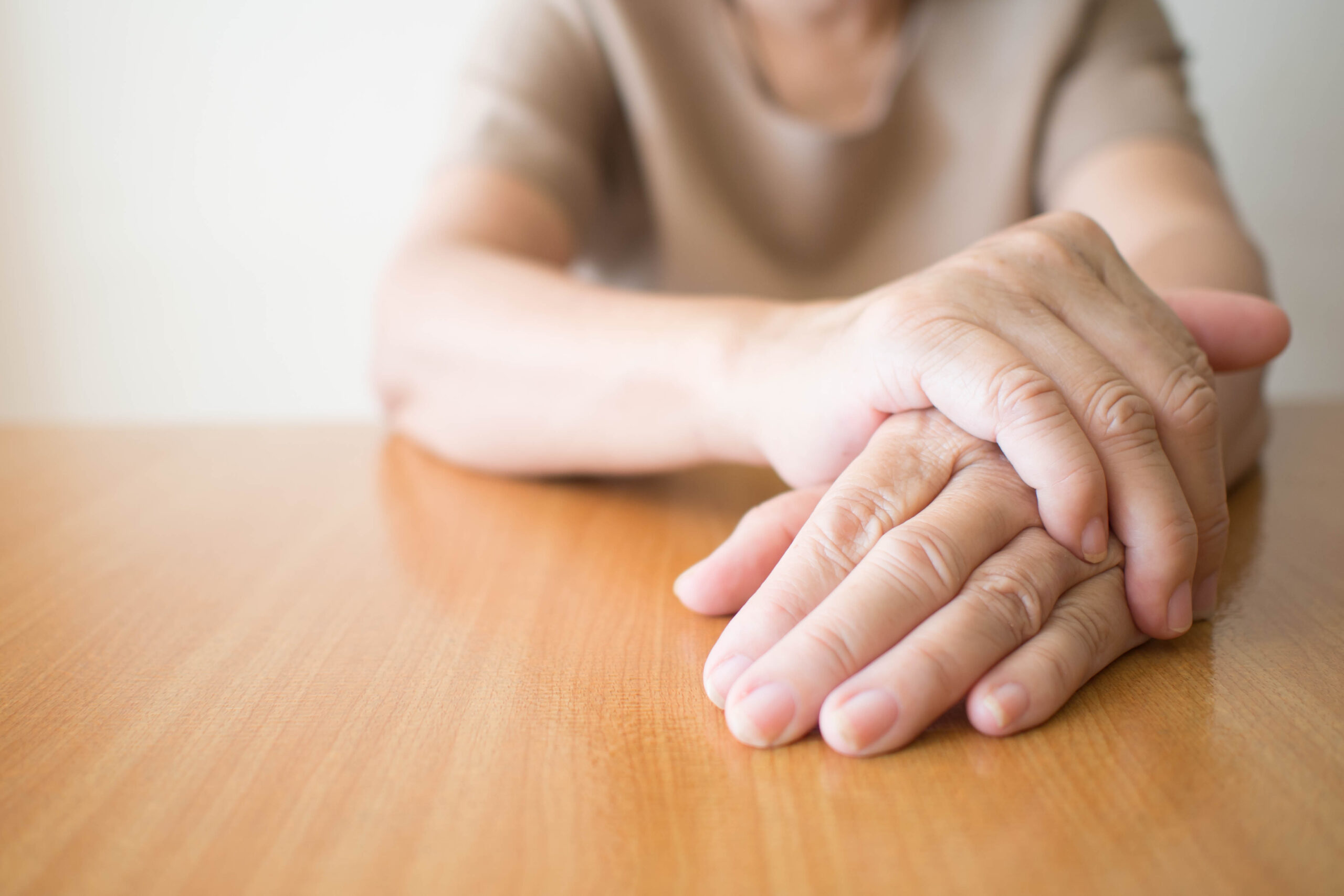 Person resting their hands on a table