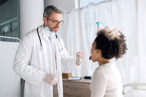 A surgeon looks at a woman's tongue.