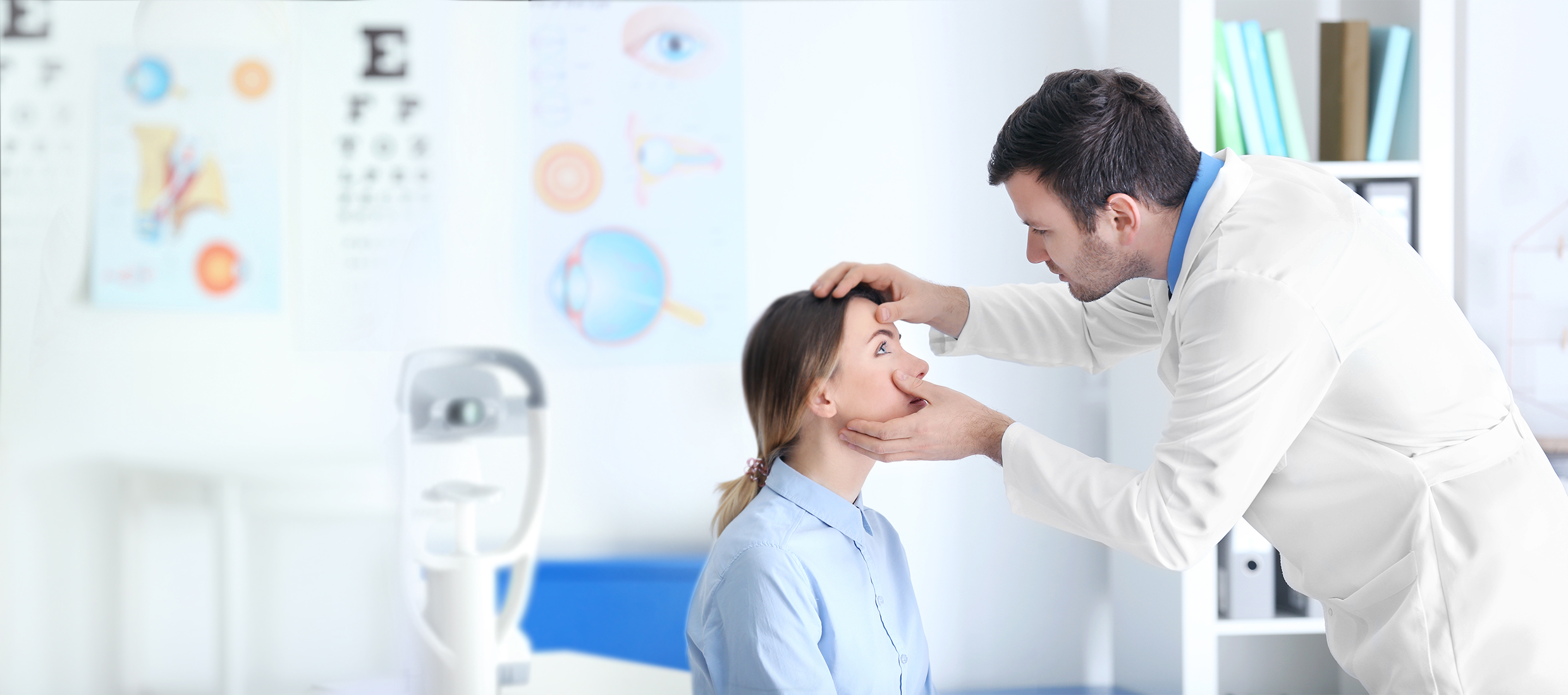 Eye care specialist examines a female patient's eyes in an examining room