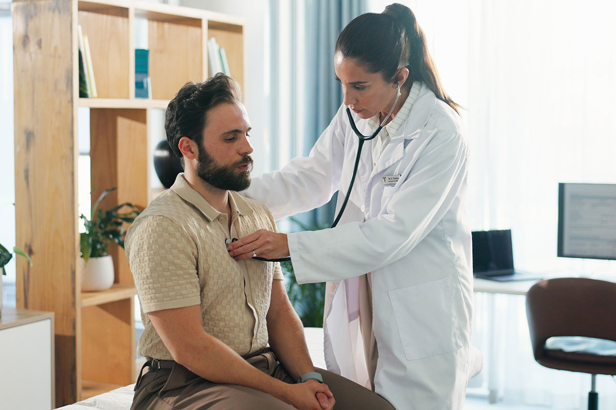 A doctor checks a patients breathing.