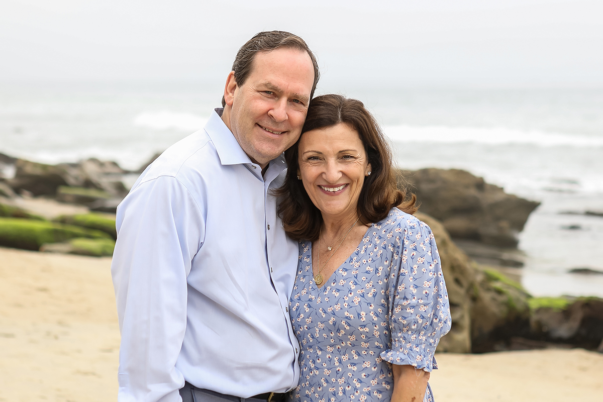 Adrienne Bolger, a Keck Medicine of USC patient, and her husband Bob Bolger, standing together and smiling at the beach