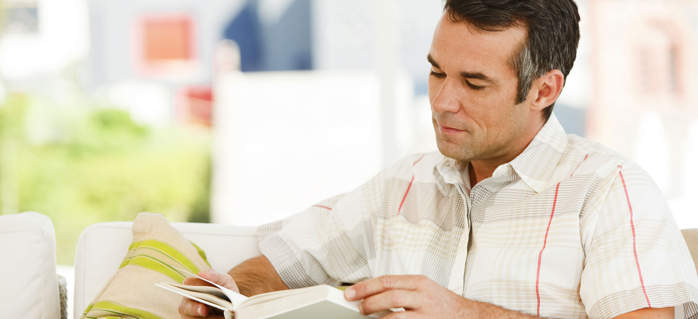 Man reading a book while sitting down