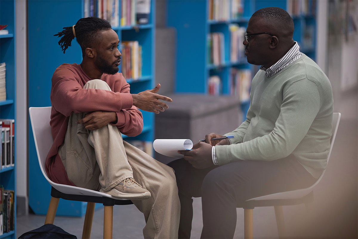 A psychiatrist speaks with a college student.