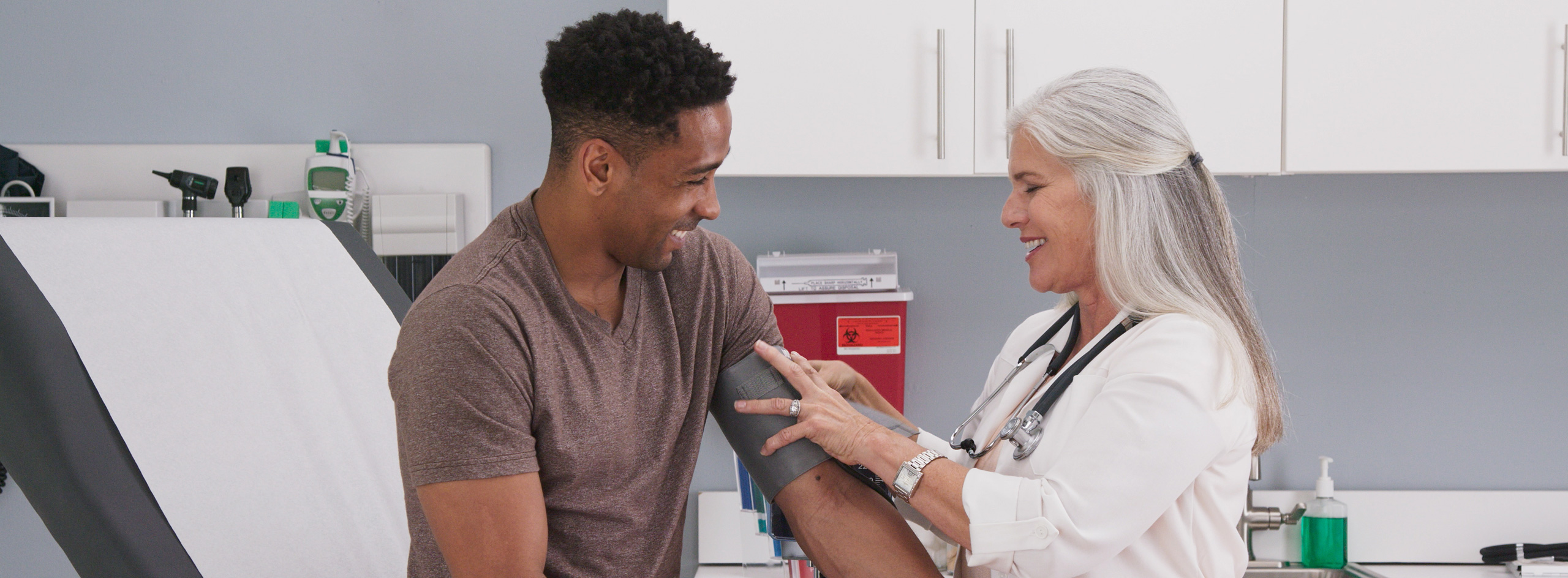 Caring female doctor takes patient’s blood pressure in hospital