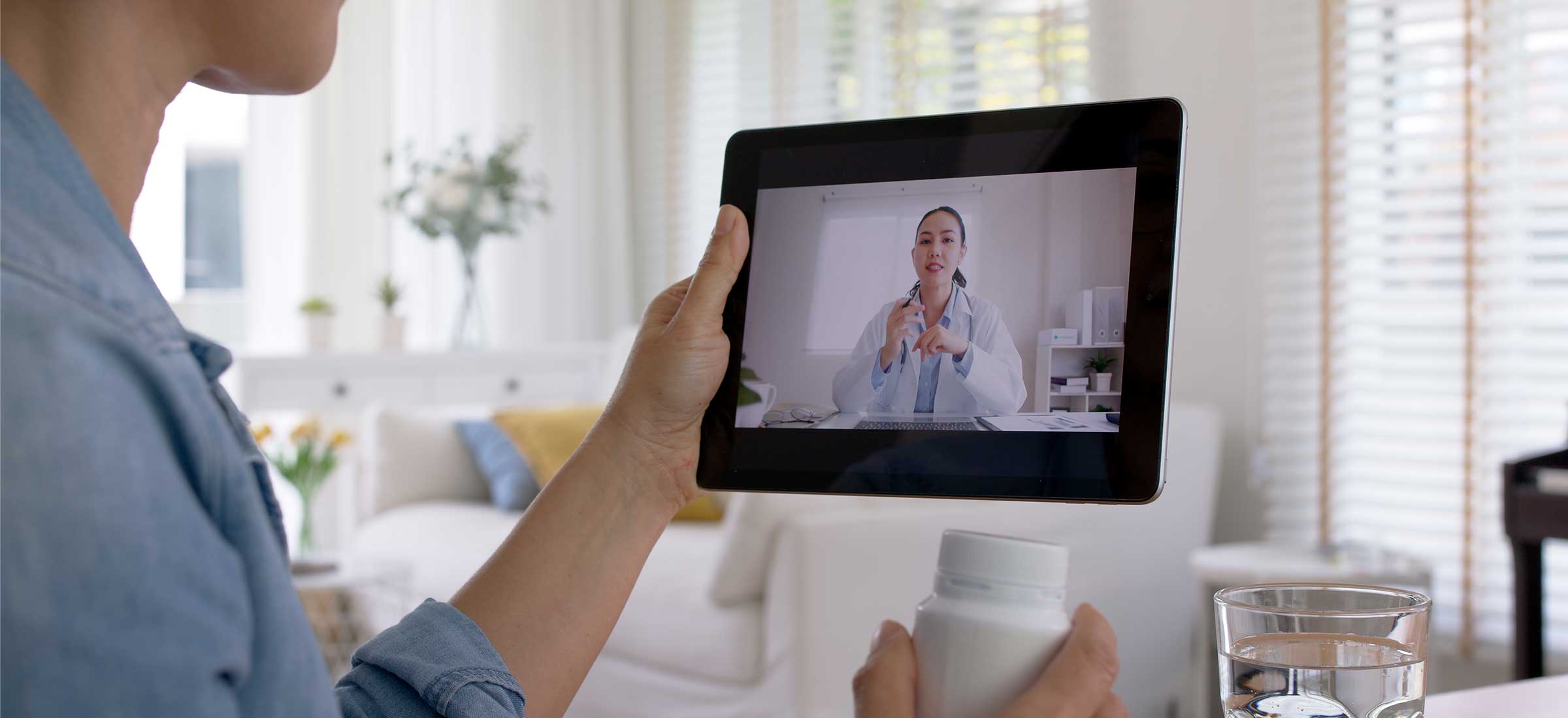 Happy adult woman sitting at home using remote video chat with online healthcare provider.
