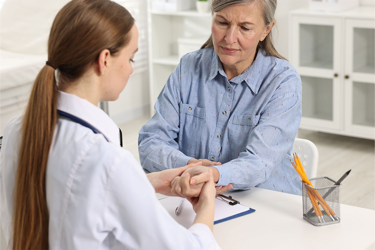 A rheumatologist checks a woman's wrist.