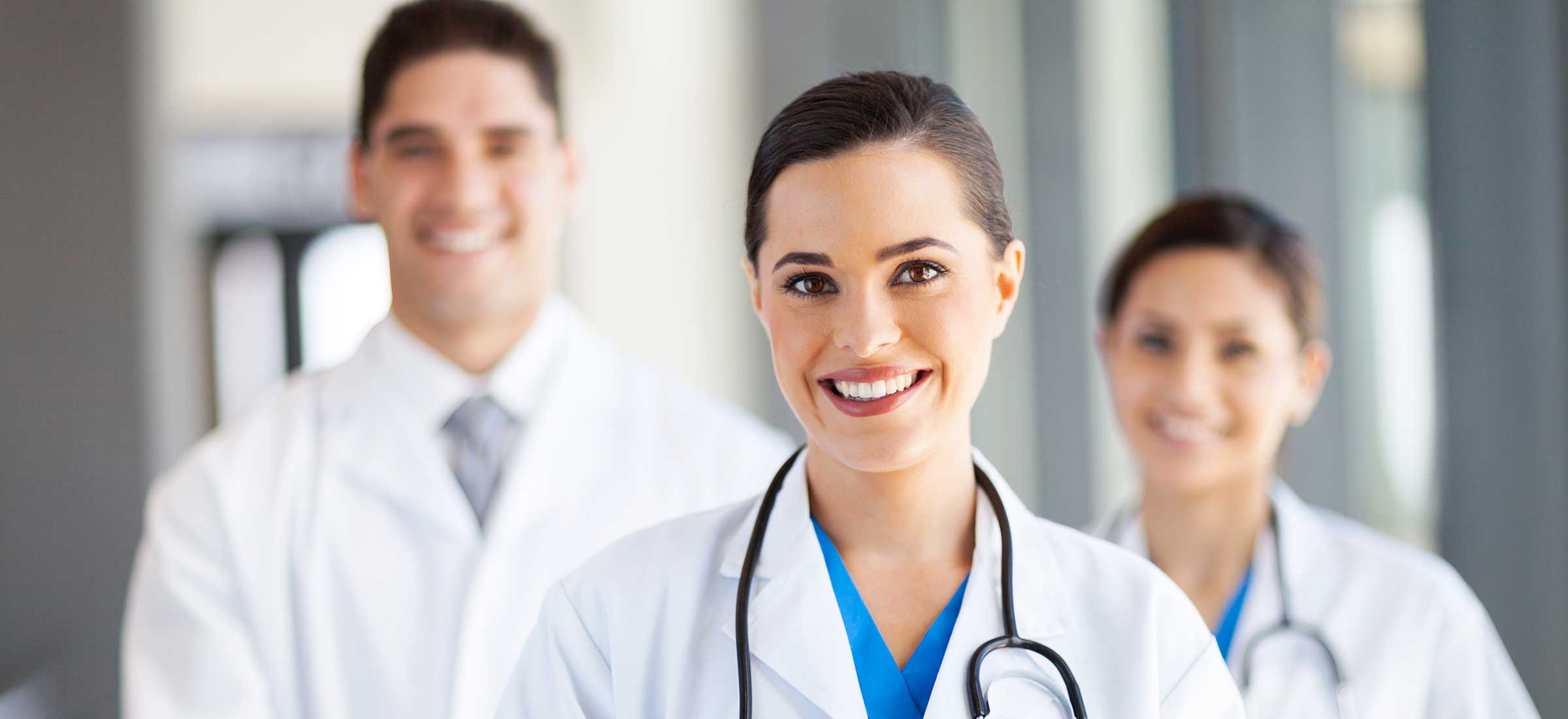 Woman doctor standing in front of her colleagues at a hospital.