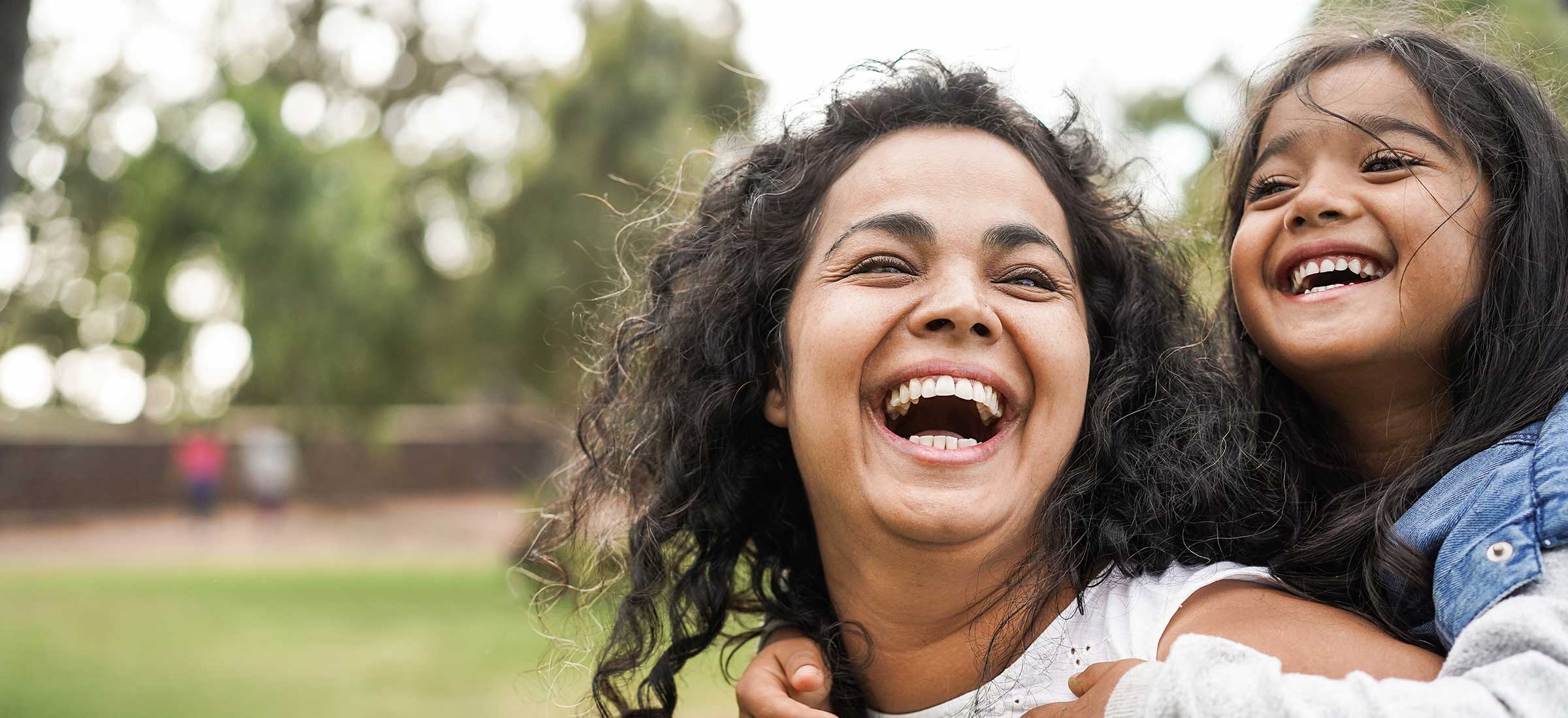 Happy Indian mother having fun with her daughter outdoors.