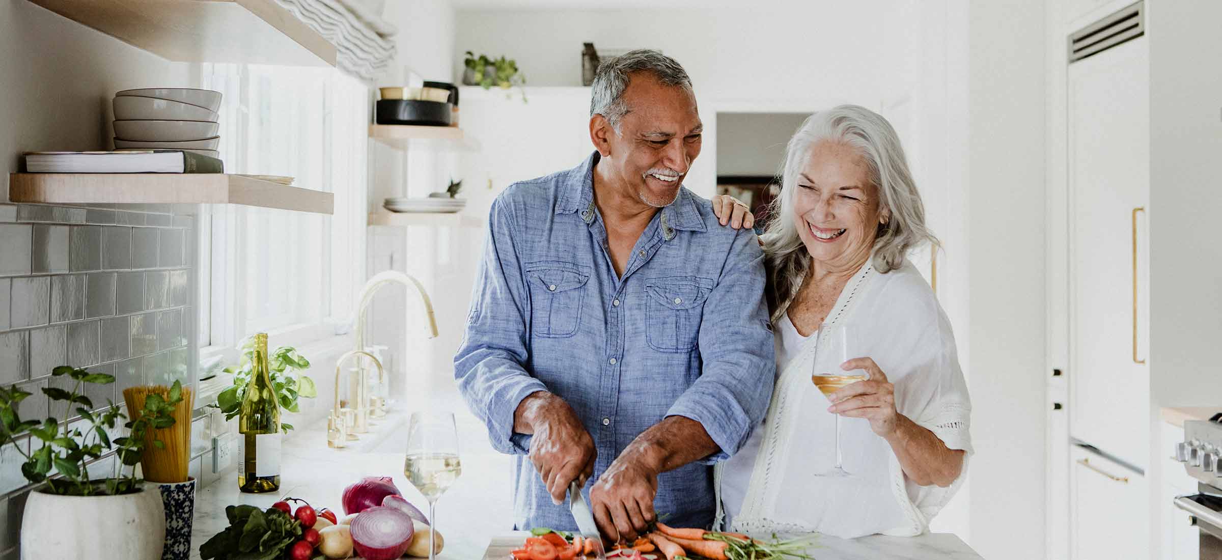 Elderly couple cooking in a kitchen.