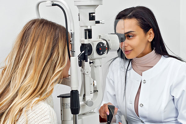 Doctor checks patient's eye with machine.