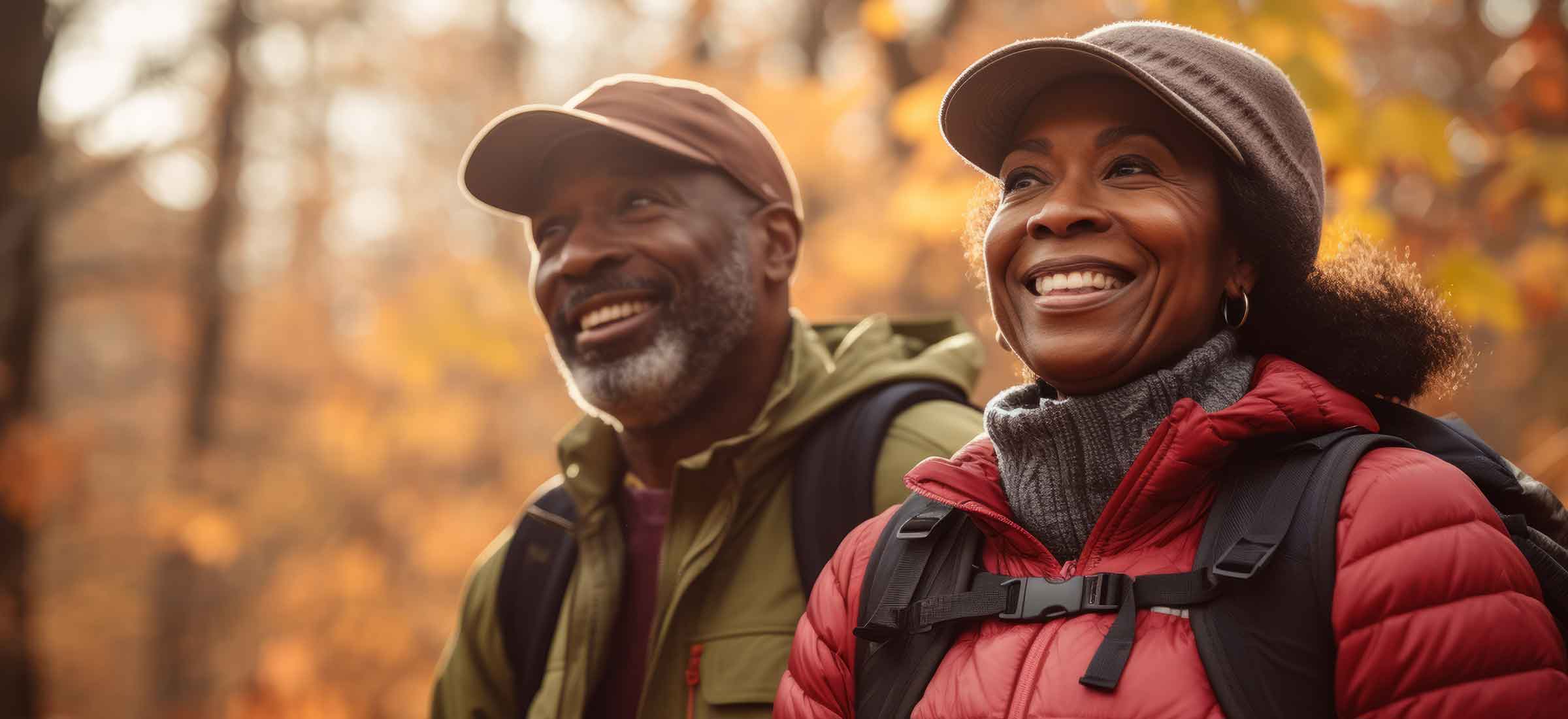 A man and a woman hike in the woods.