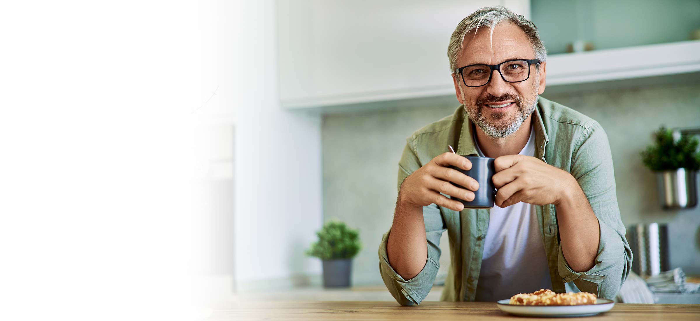 Person holding a cup in a kitchen