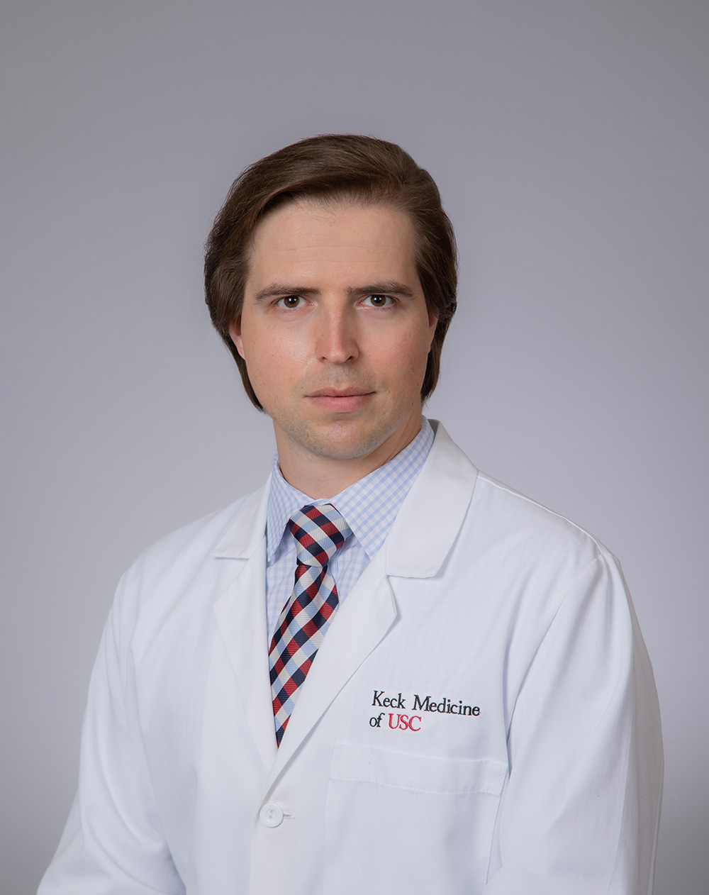 A portrait of Serge Kobsa in a white medical coat.