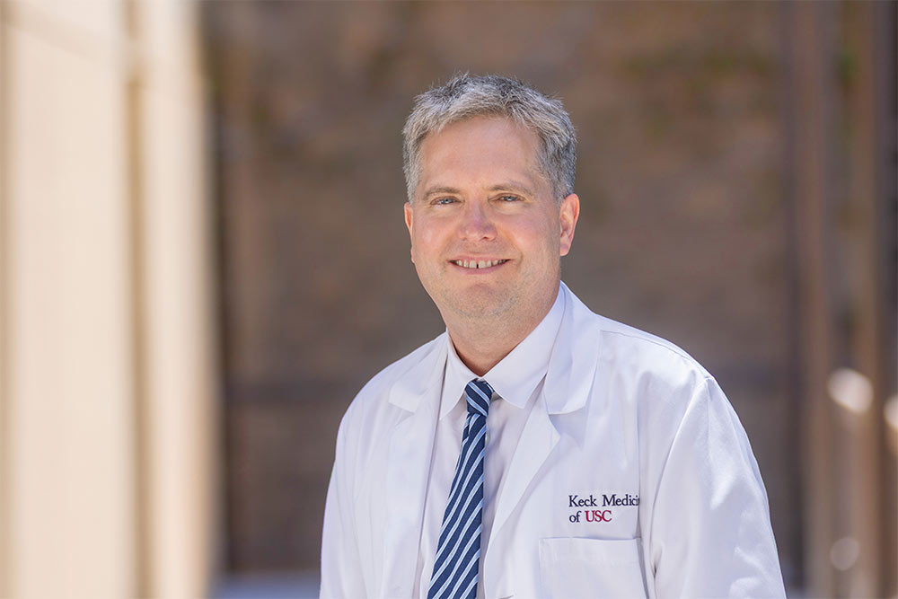 Dr. James Buxbaum stands outside and smiles.