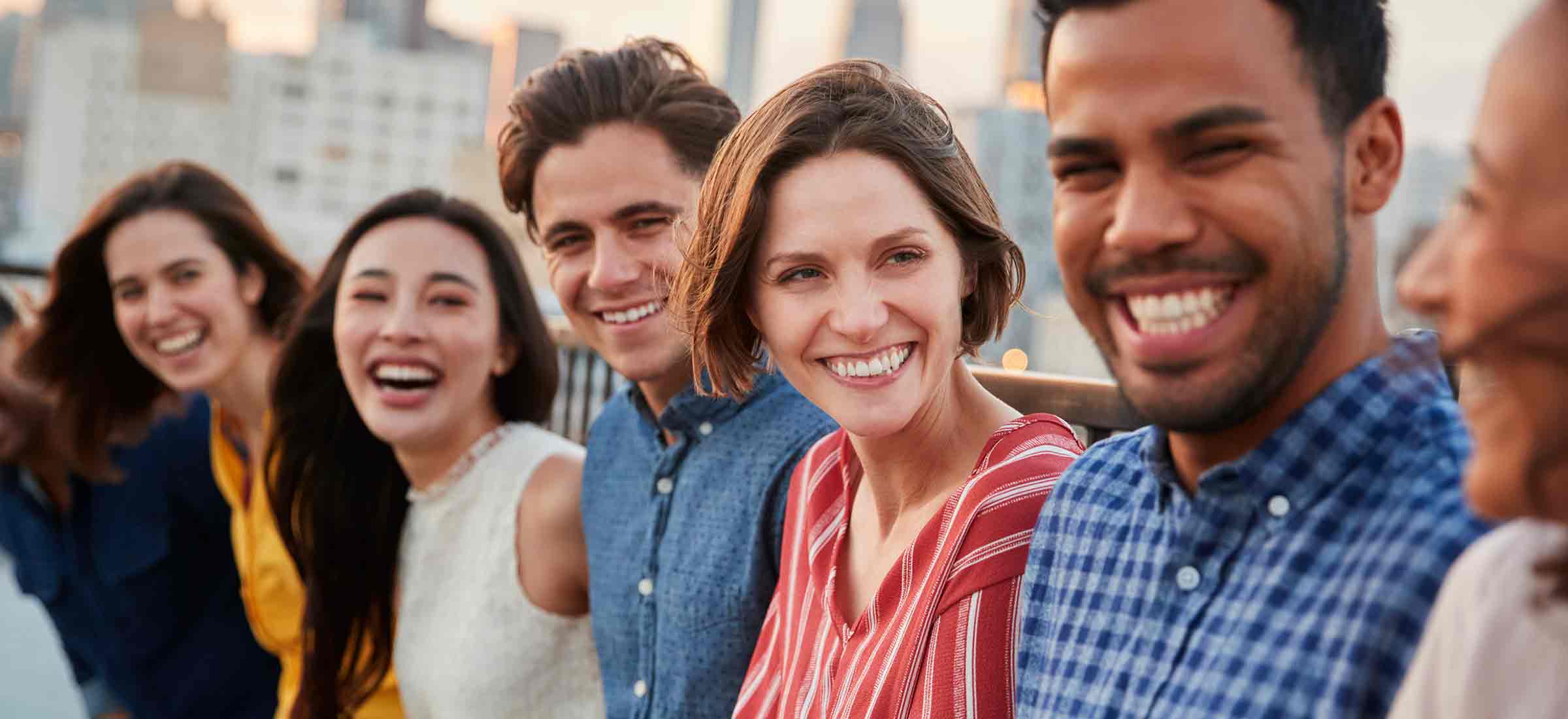 A group of people smiles on a deck outside.