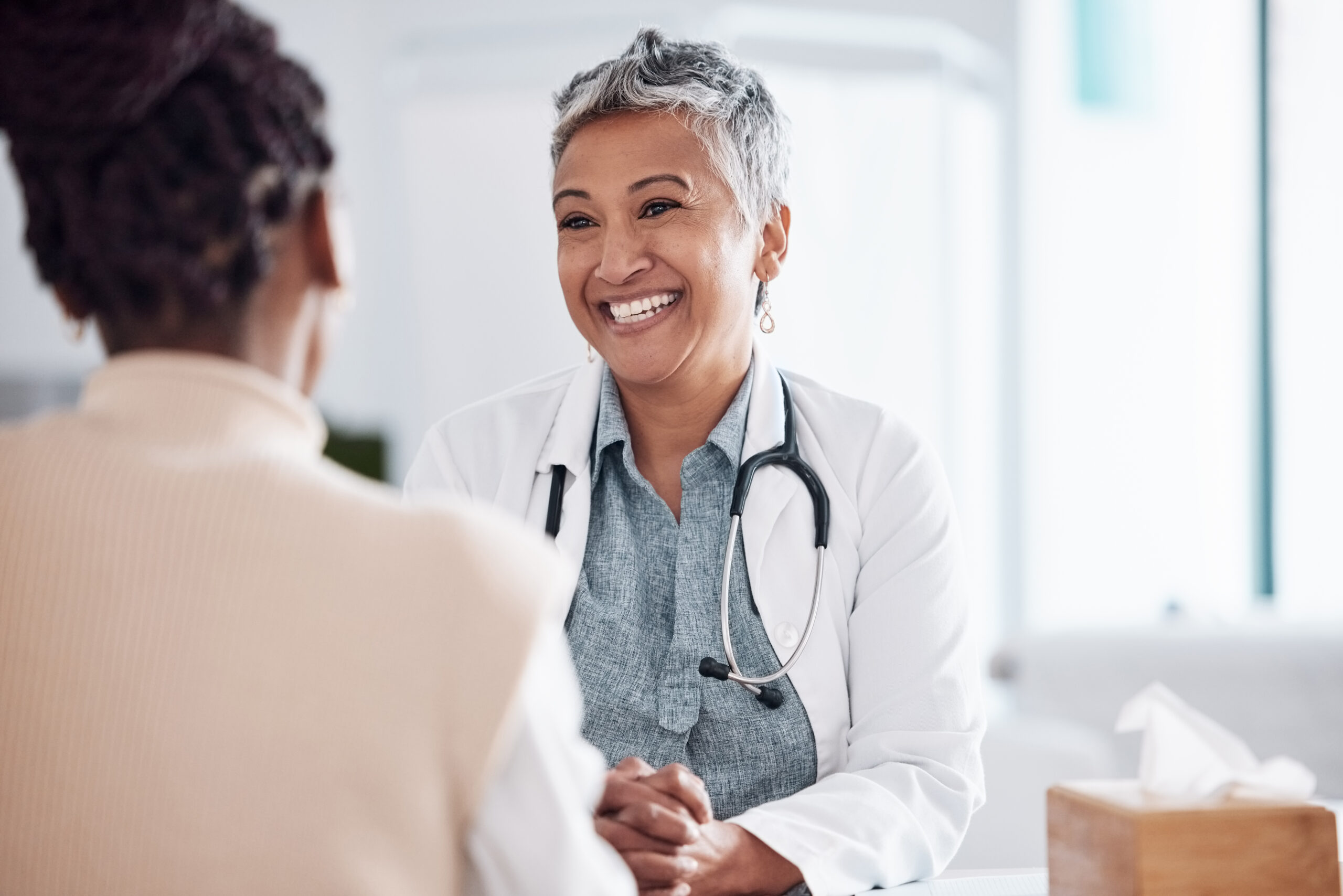 Image of Happy, mature or doctor consulting a patient in meeting in hospital for healthcare help, feedback or support. People, medical or nurse with woman talking or speaking of test results or advice
