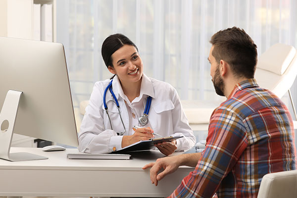 Doctor talks to male patient in doctor's office