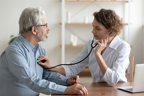 A doctor checks a man for aortic aneurysm.