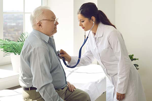 A doctor checks a man's heart.