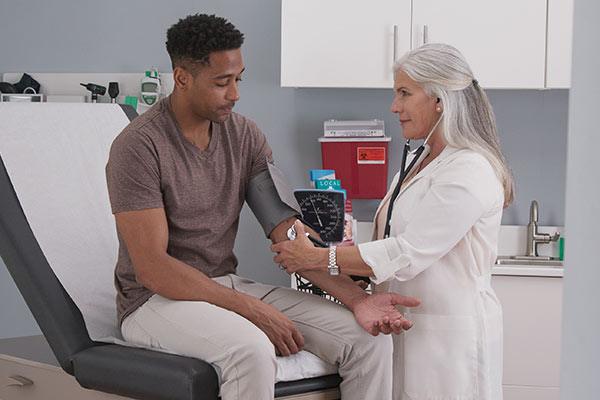 A woman checks a man for an inherited cardiovascular disorder.
