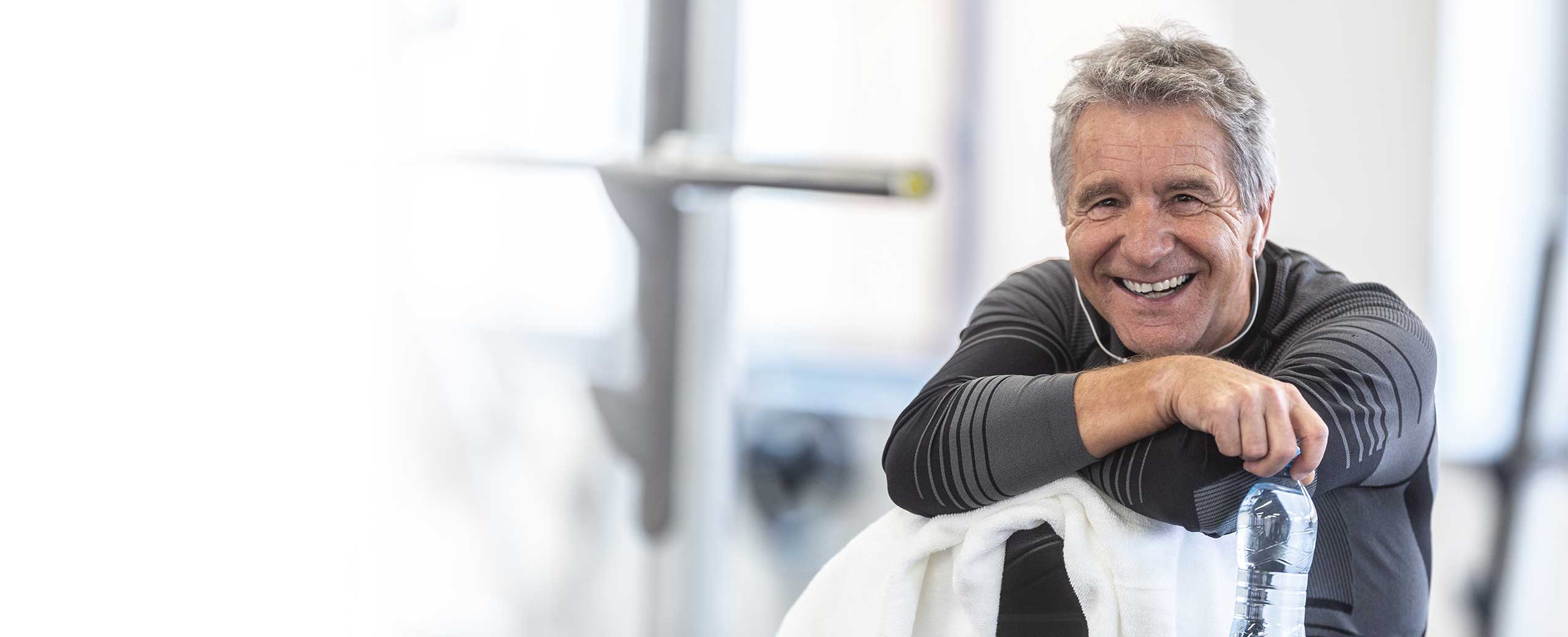 A man smiles while sitting down.