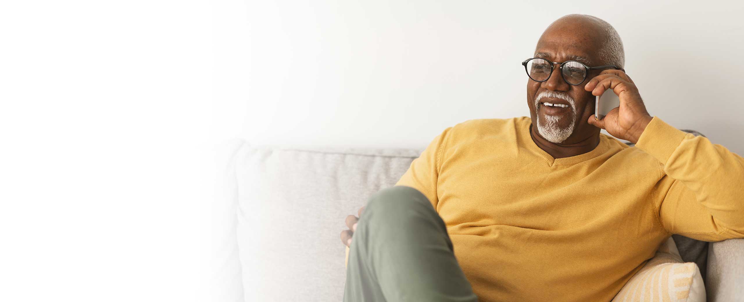 A man with cardiomyopathy sits on a couch.