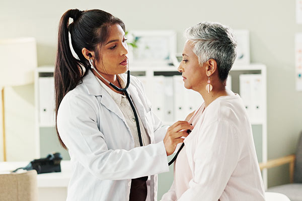 A doctor checks a woman's heart for a conduction disorder.