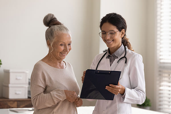 A woman speaks with her cardiologist about a coronary atherectomy.