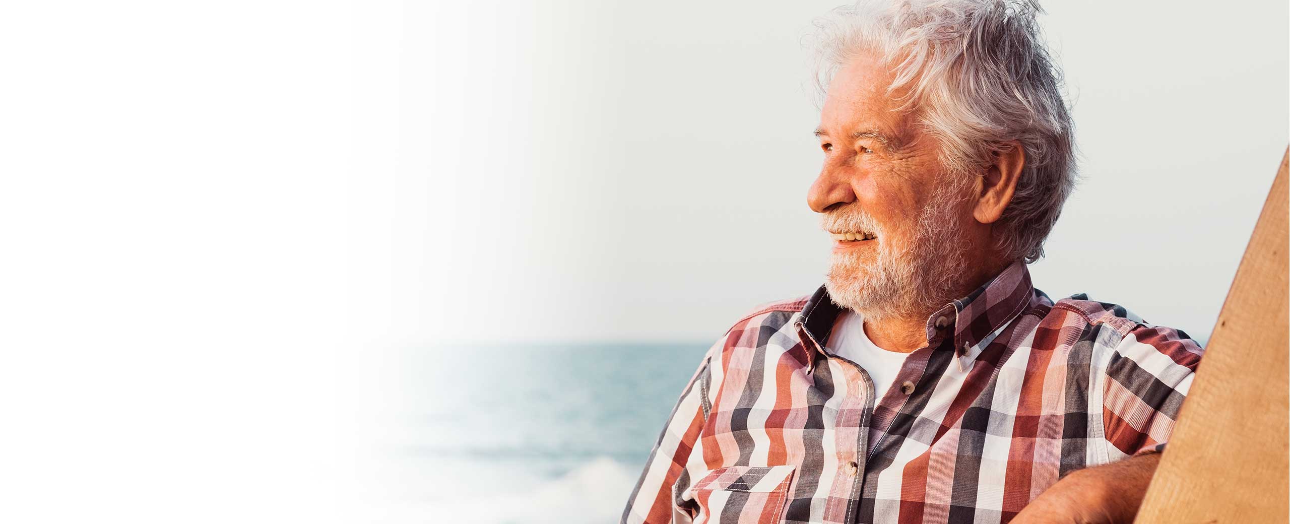 A man smiles and looks out at the ocean.