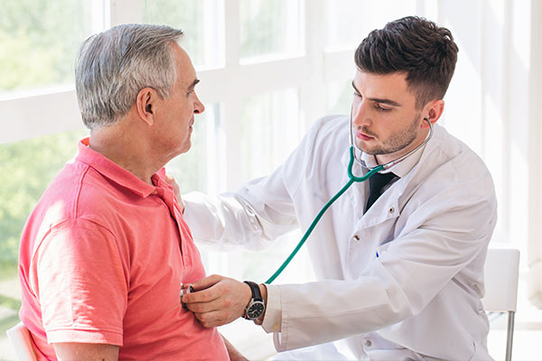 A doctor checks a man's heart for signs of heart valve disease.