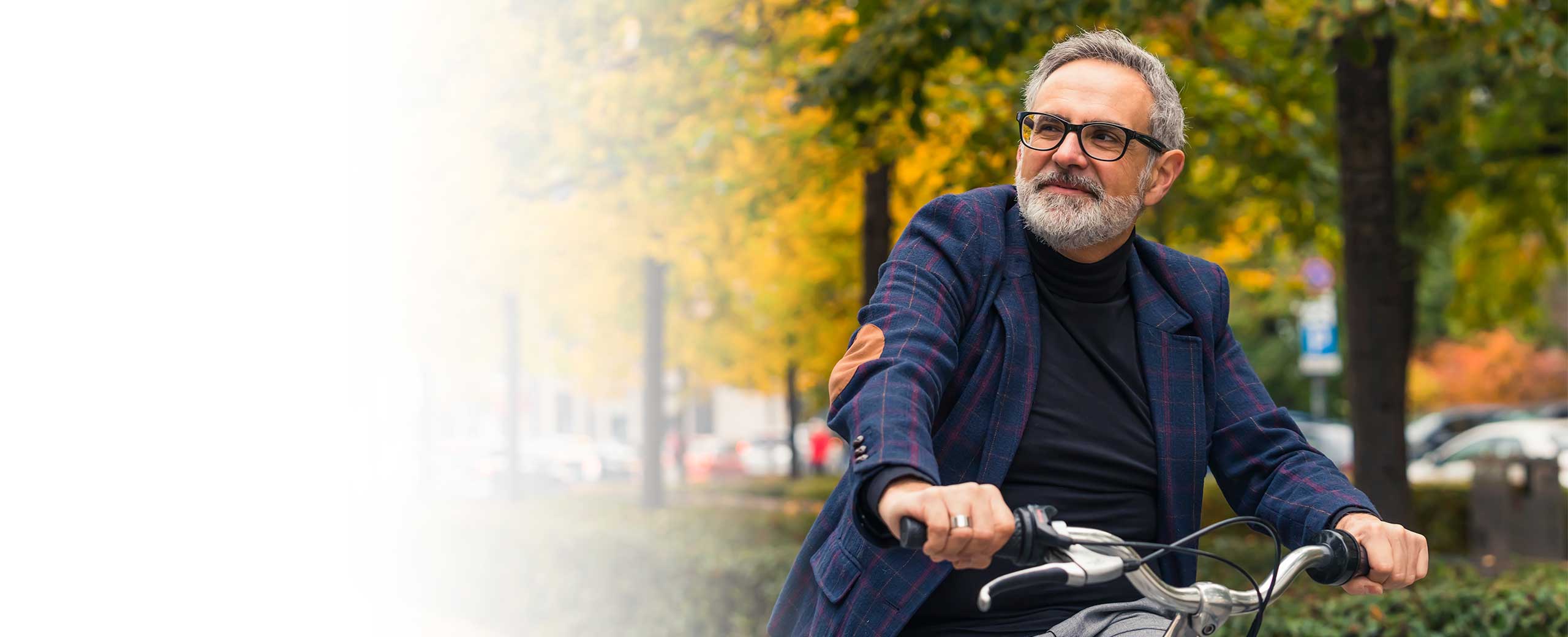 A man rides a bike in the park.