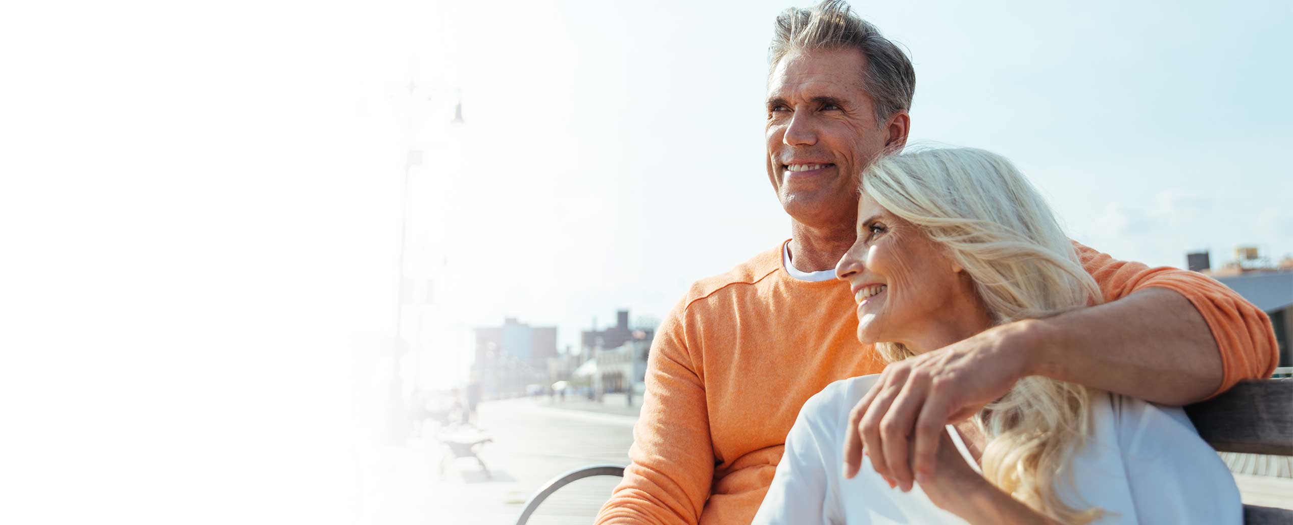 A man holds a woman as they both smile.